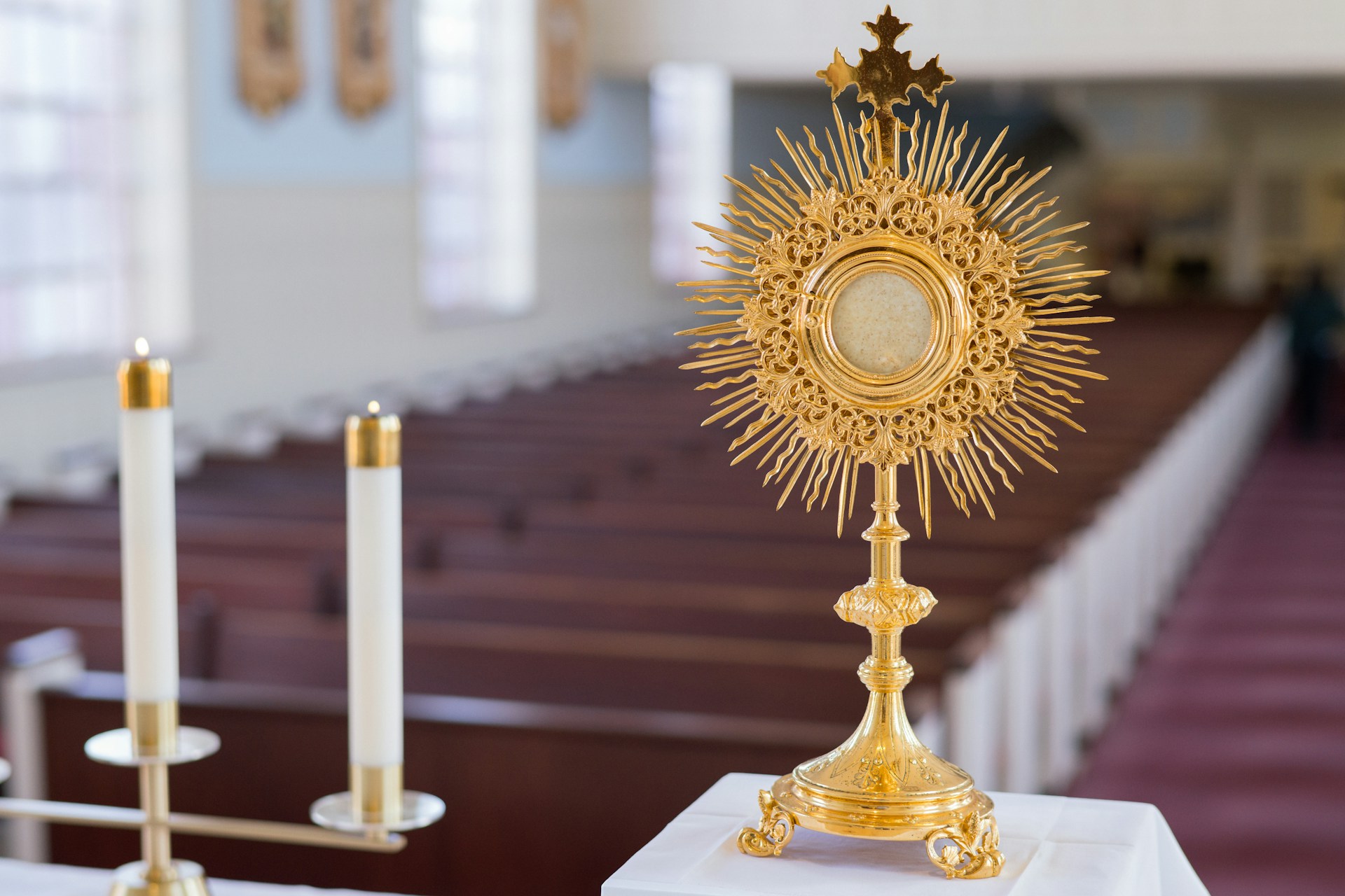 A golden monstrance with candles in church.