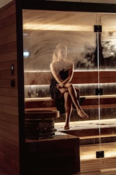 Woman relaxing in a steamy wooden sauna.