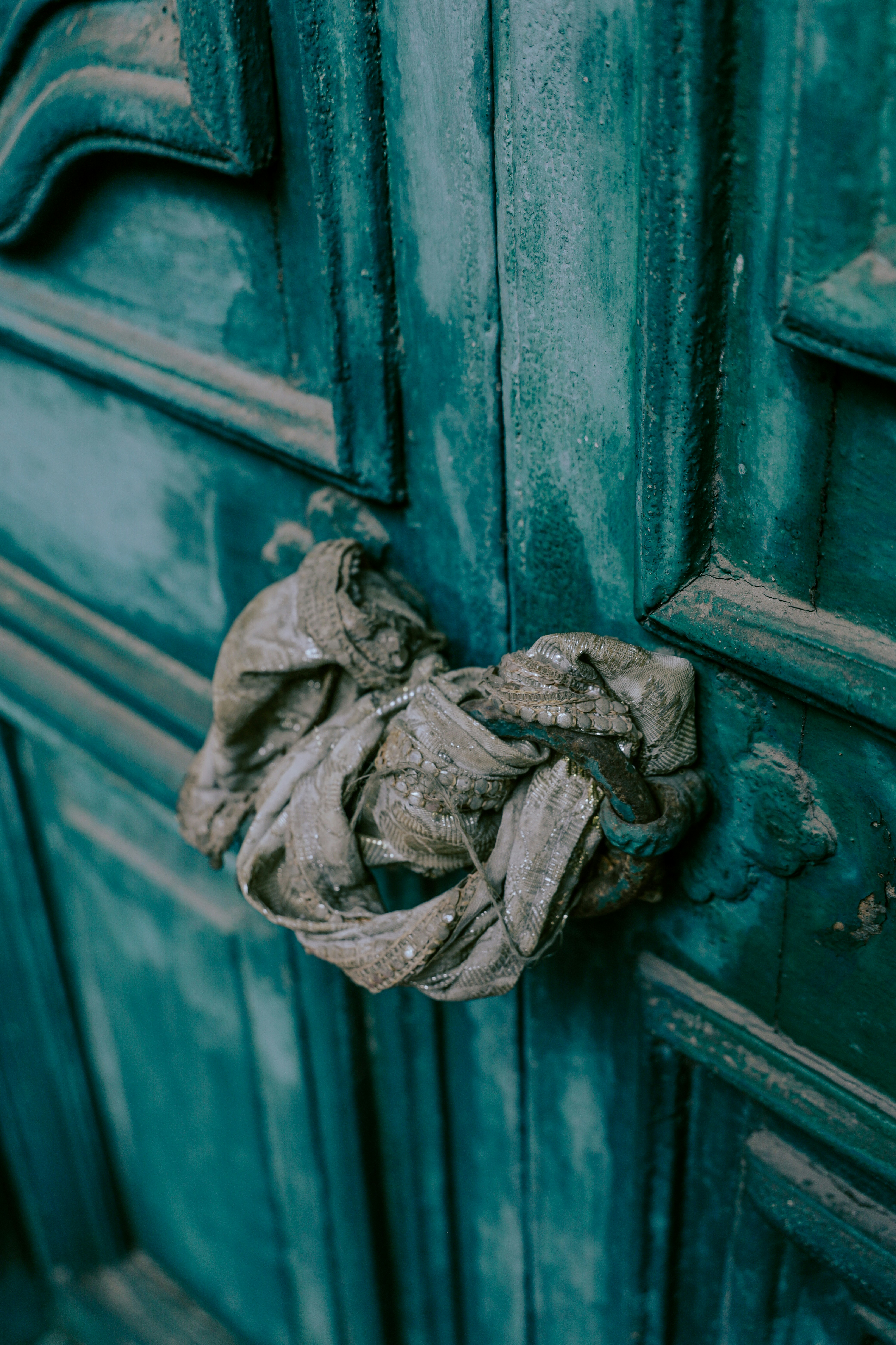 Un tissu froissé sur une porte en bois bleu sarcelle