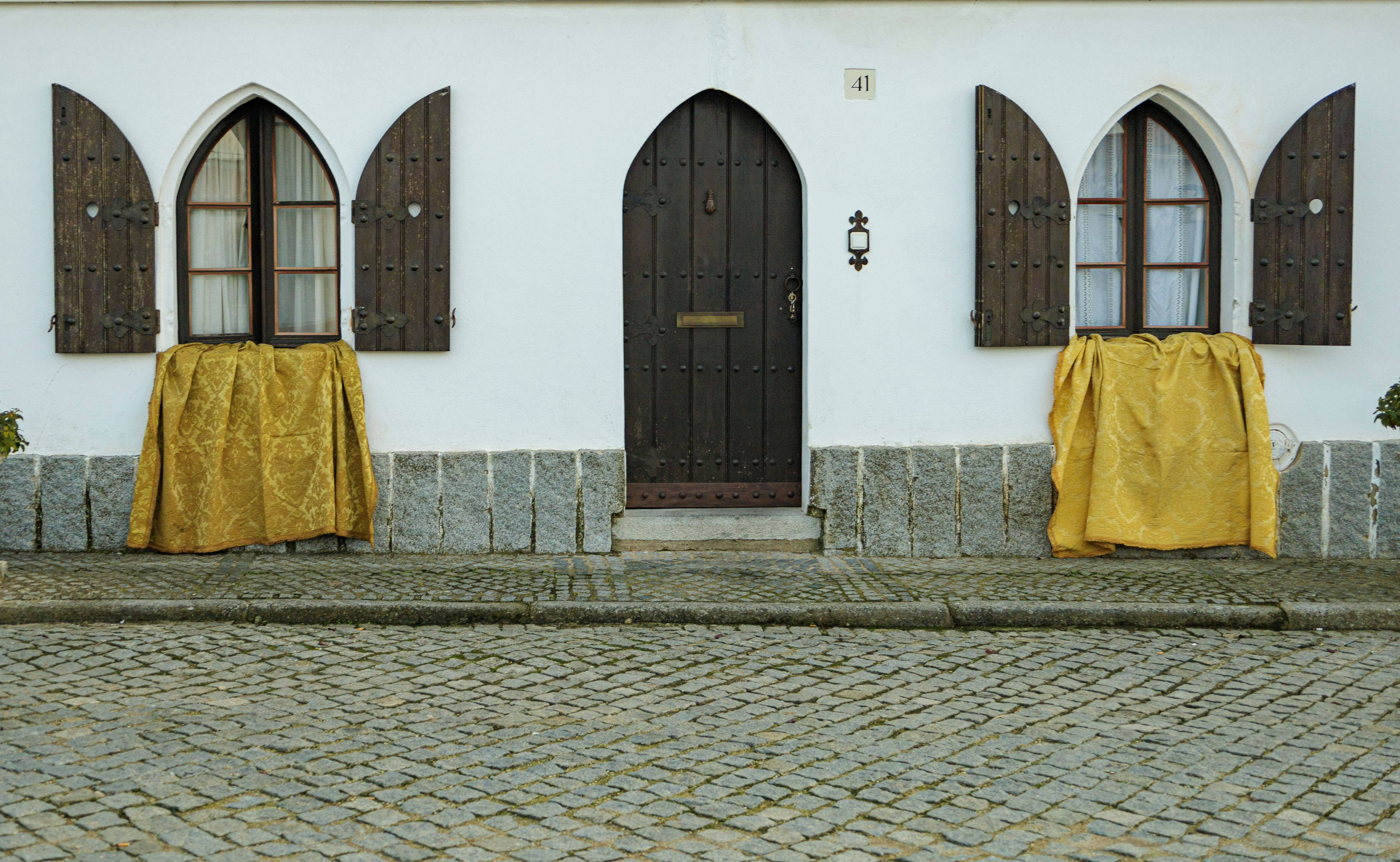 White building with arched windows and wooden door