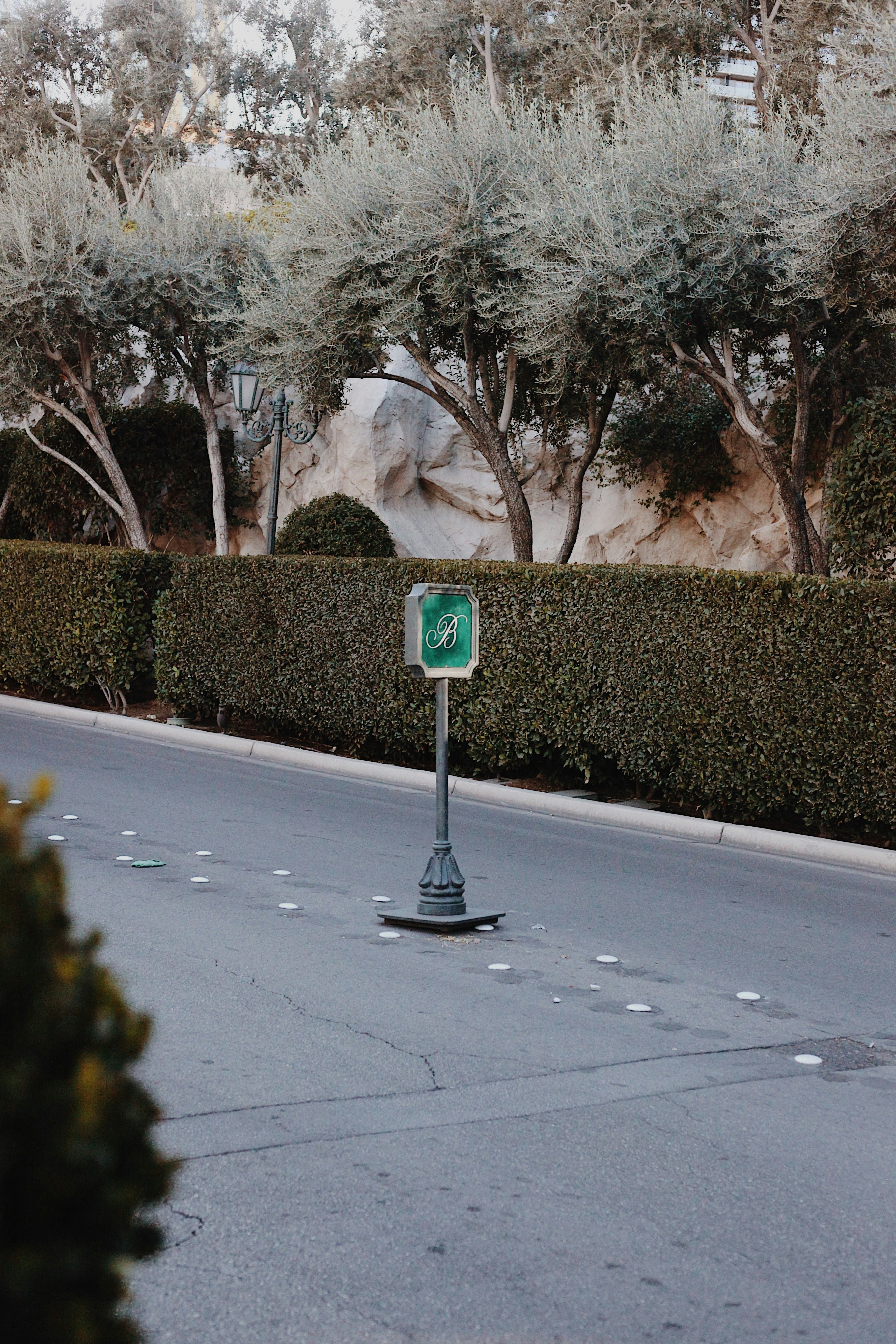 Uma placa verde está em uma estrada pavimentada.