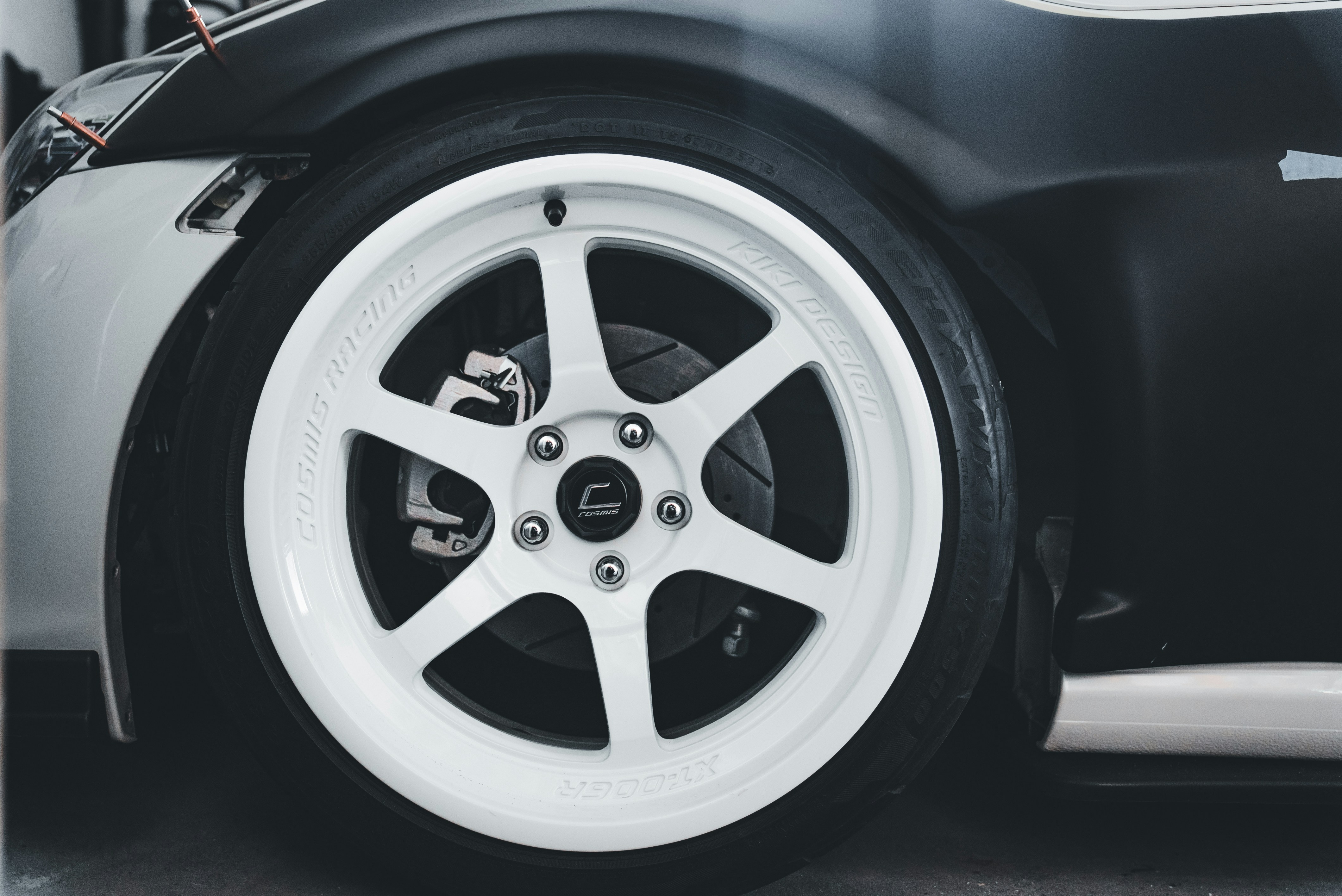 Close-up of a white car wheel with black tire.