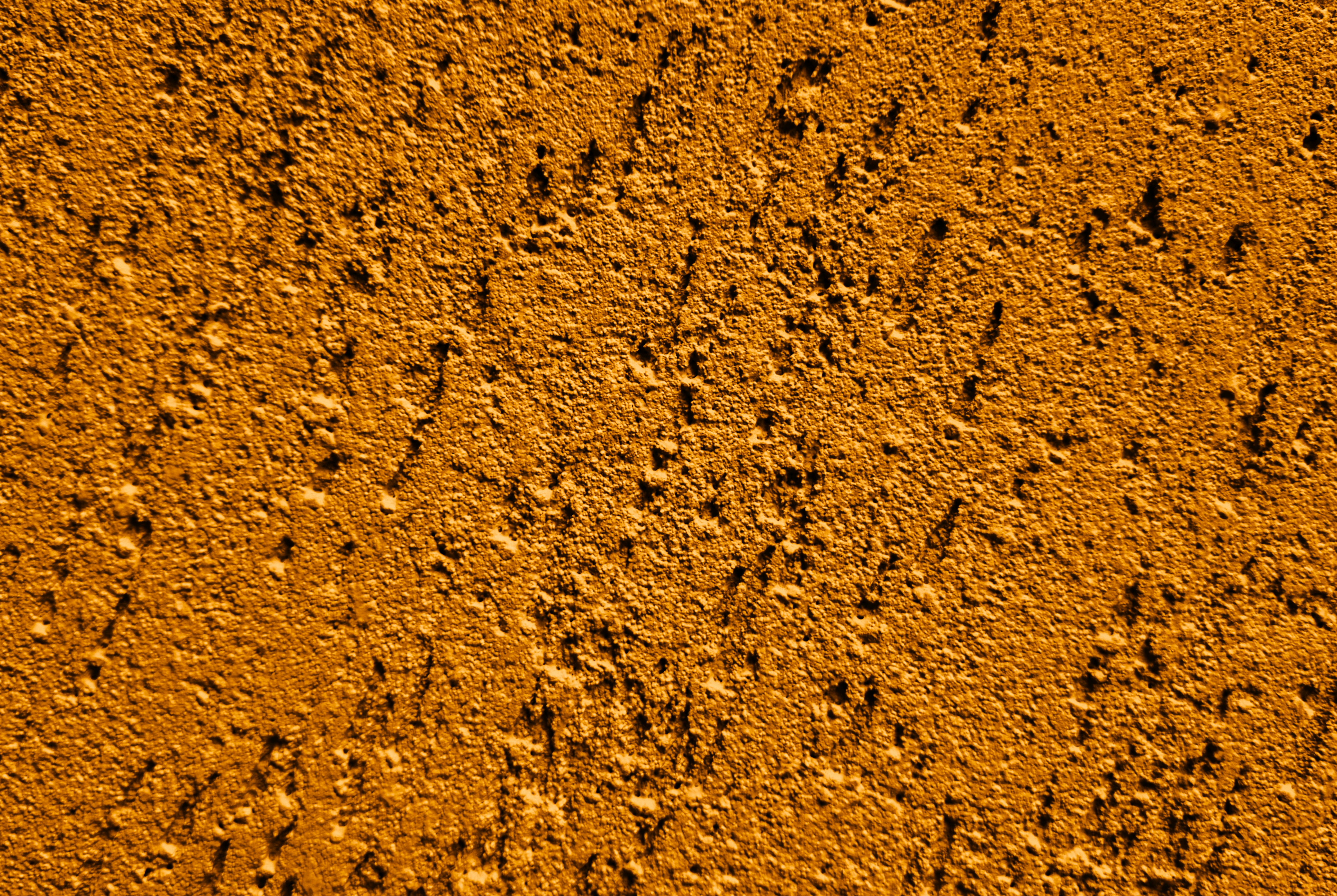 Pared naranja texturizada con pequeños bultos y sombras