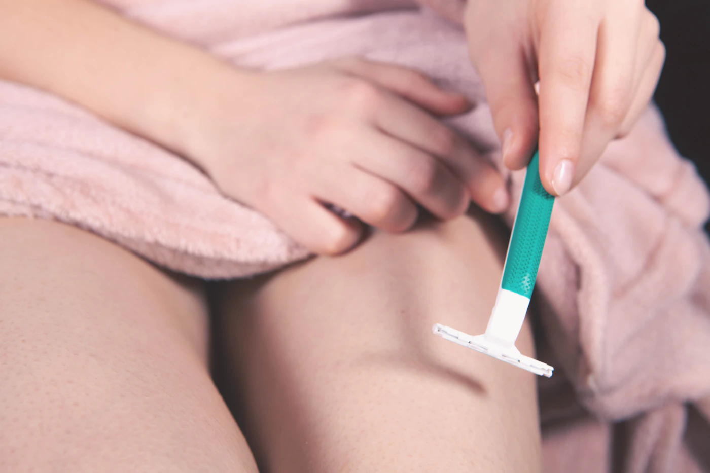 Close-up of a person shaving their leg, representing the routine that laser hair removal aims to reduce the need for over a treatment course