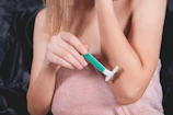 Woman shaving her arm with a razor.