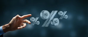 Hand reaching towards floating percentage symbols.