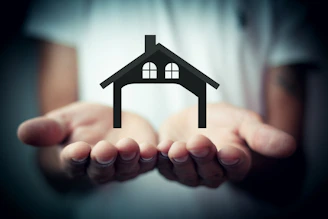 Hands holding a silhouette of a house