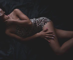 Woman lying on dark fabric with hand on chest