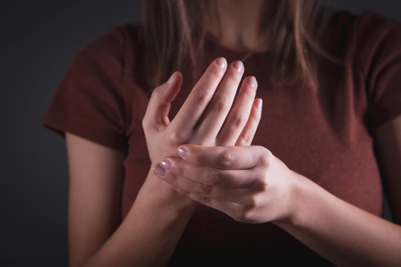 Mujer sujet&aacute;ndose la mano con dolor: dolor articular