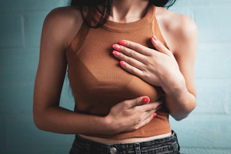 Woman holding her chest in pain