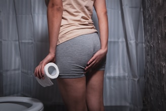 Person holding toilet paper, touching backside