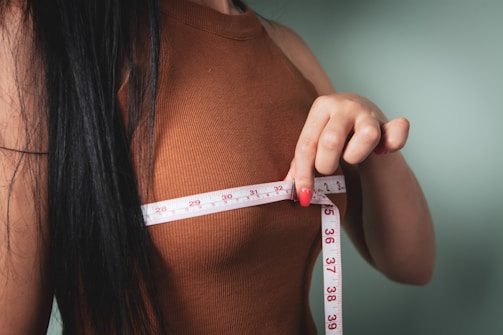 Woman measuring her bust with a tape measure.