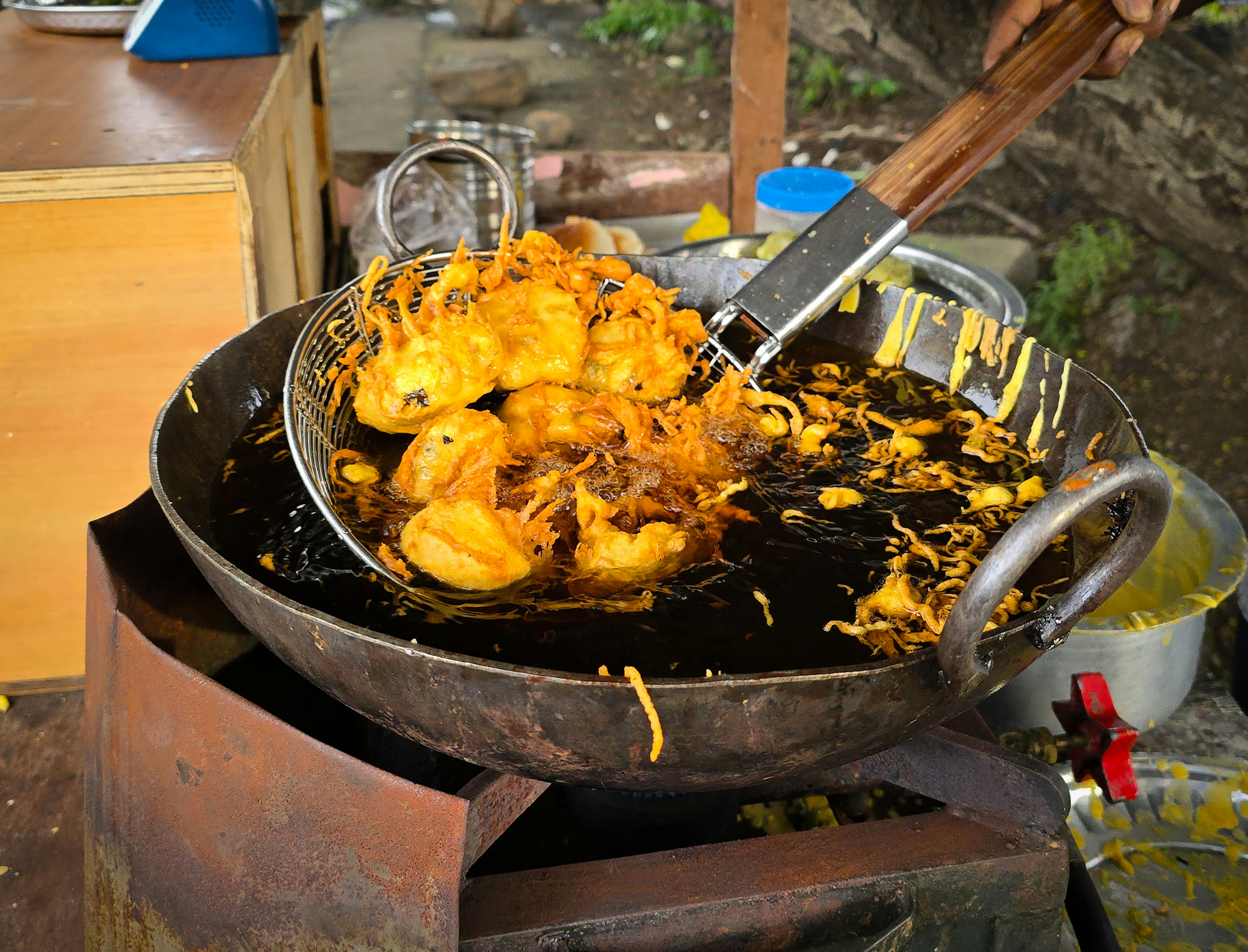 Fritters being fried in a large wok