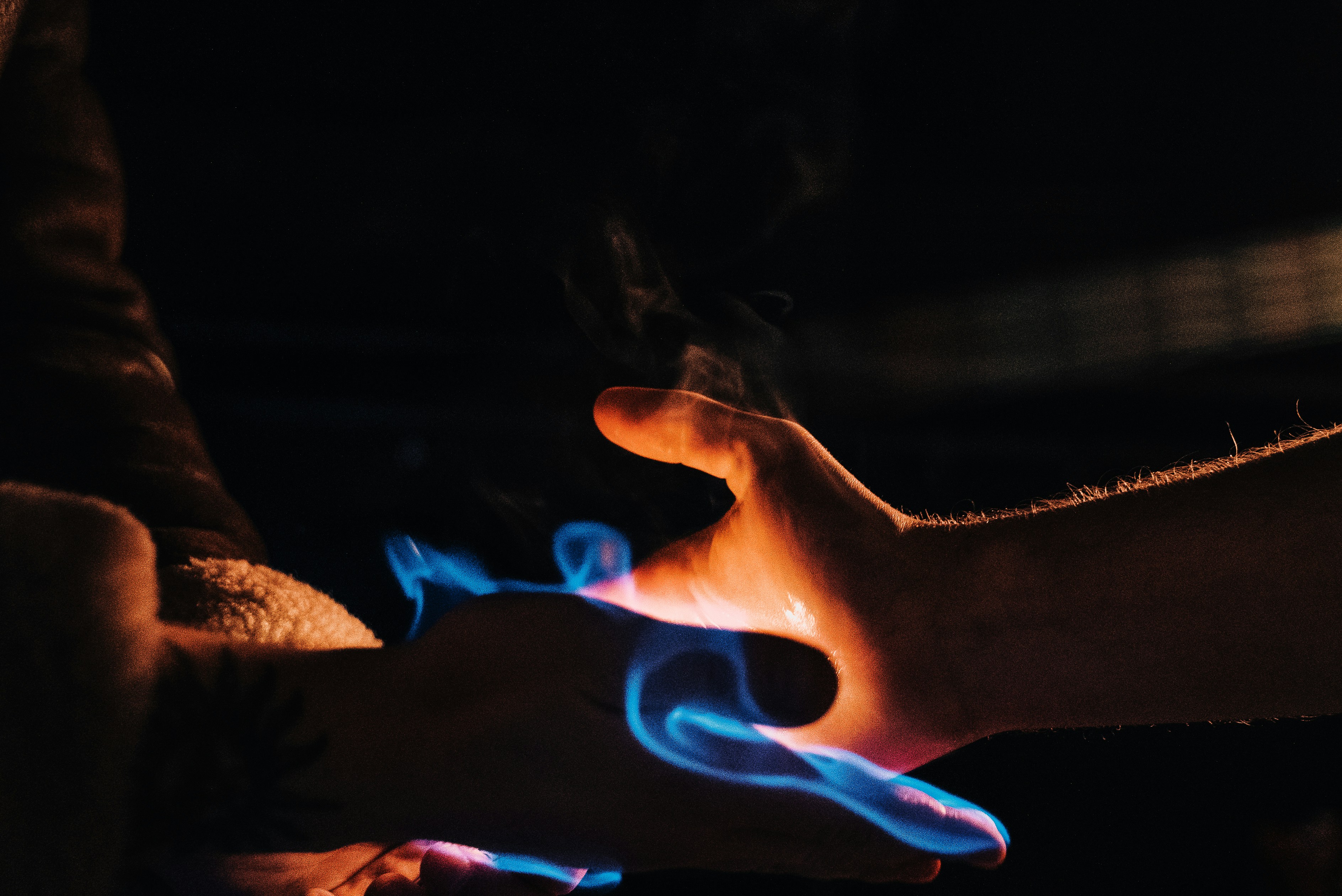 Hands with blue and orange flames