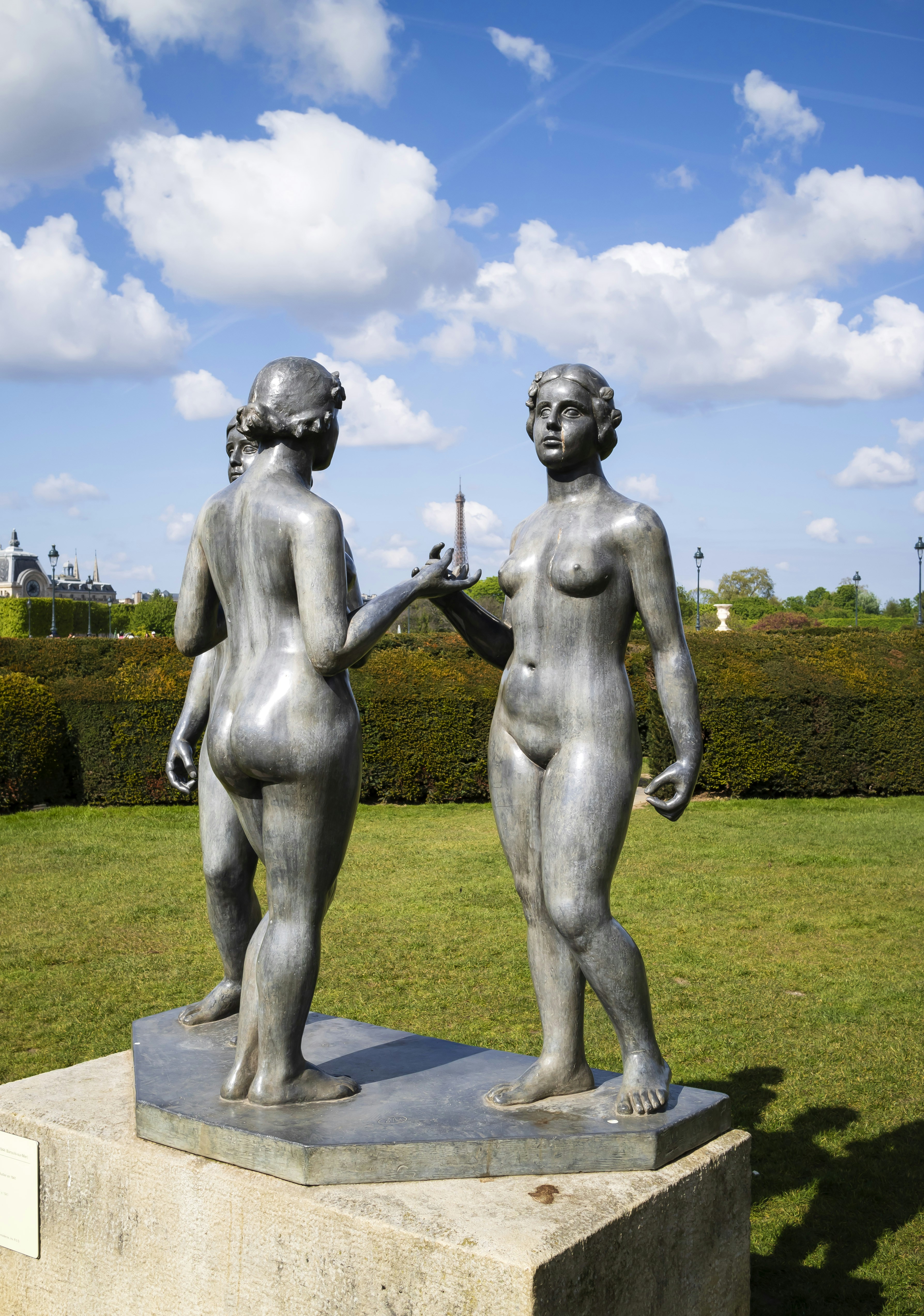Three nude women statues in a garden