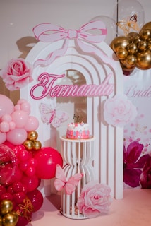 Pink and gold birthday party decorations with cake.