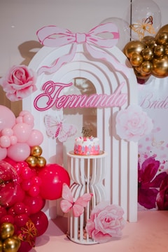 Pink and gold birthday party decorations with cake.