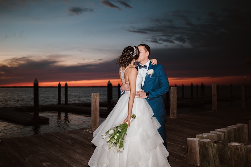 Pareja besándose en muelle al atardecer