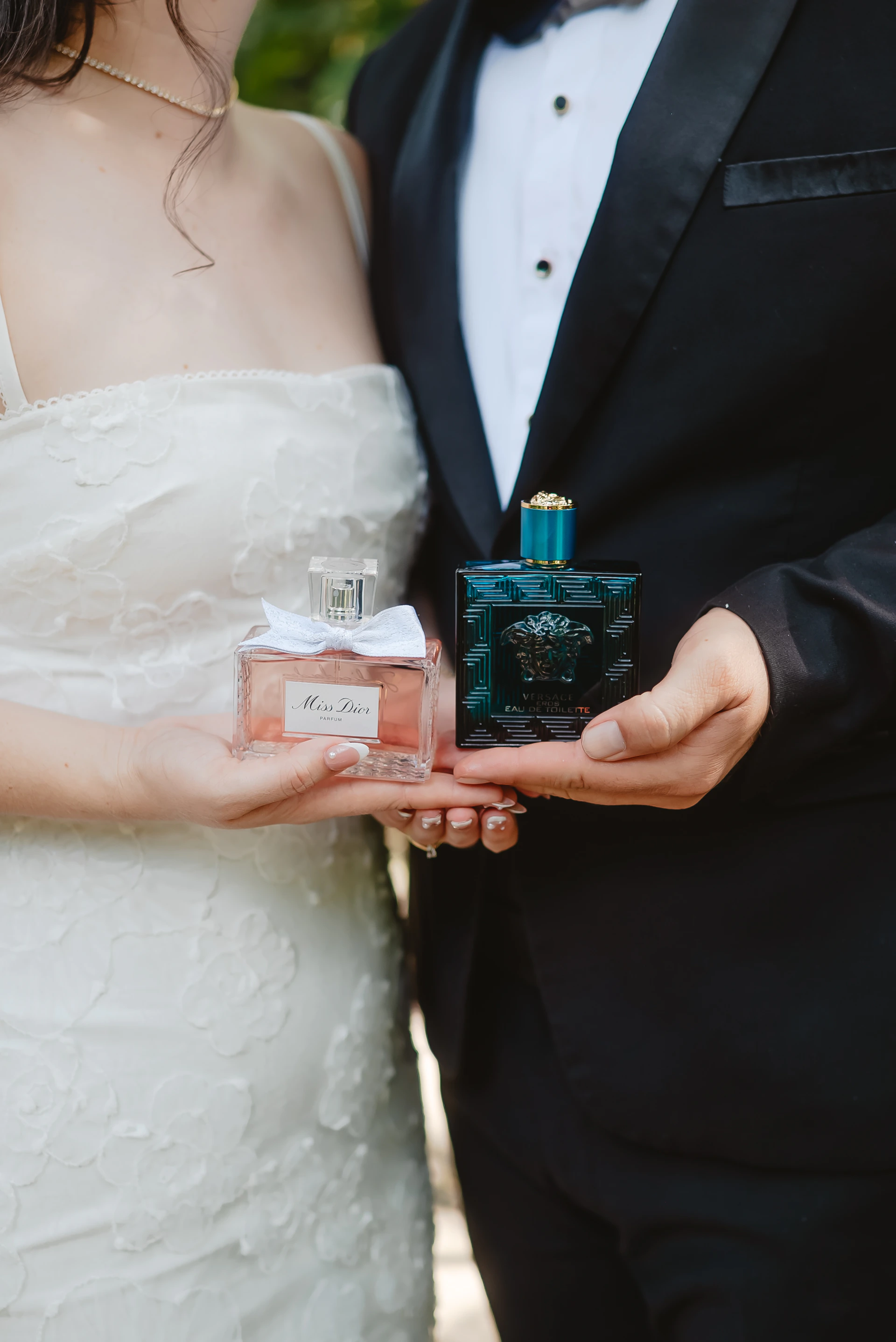 Couple holding perfume bottles on wedding day