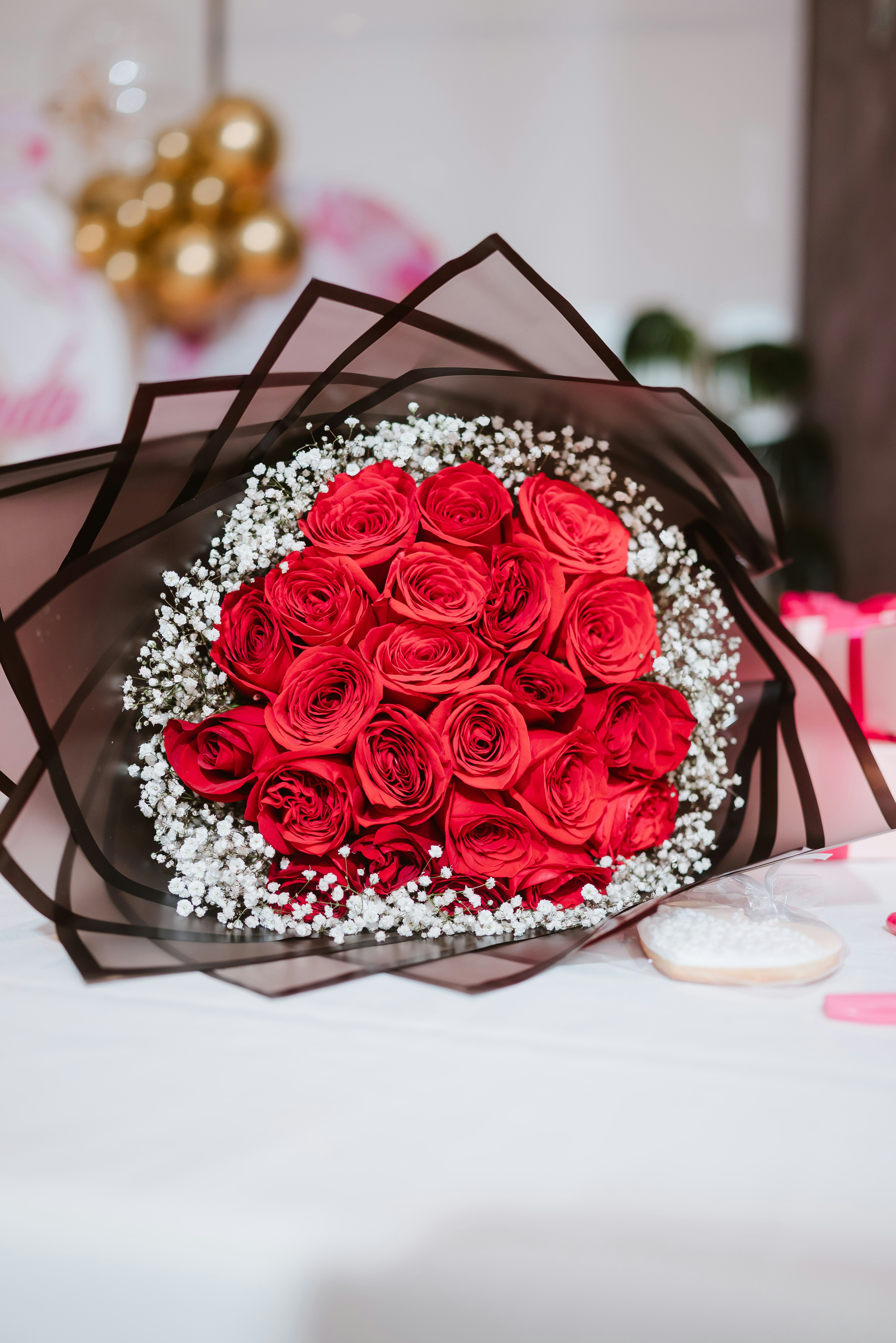 A bouquet of red roses with white baby's breath.