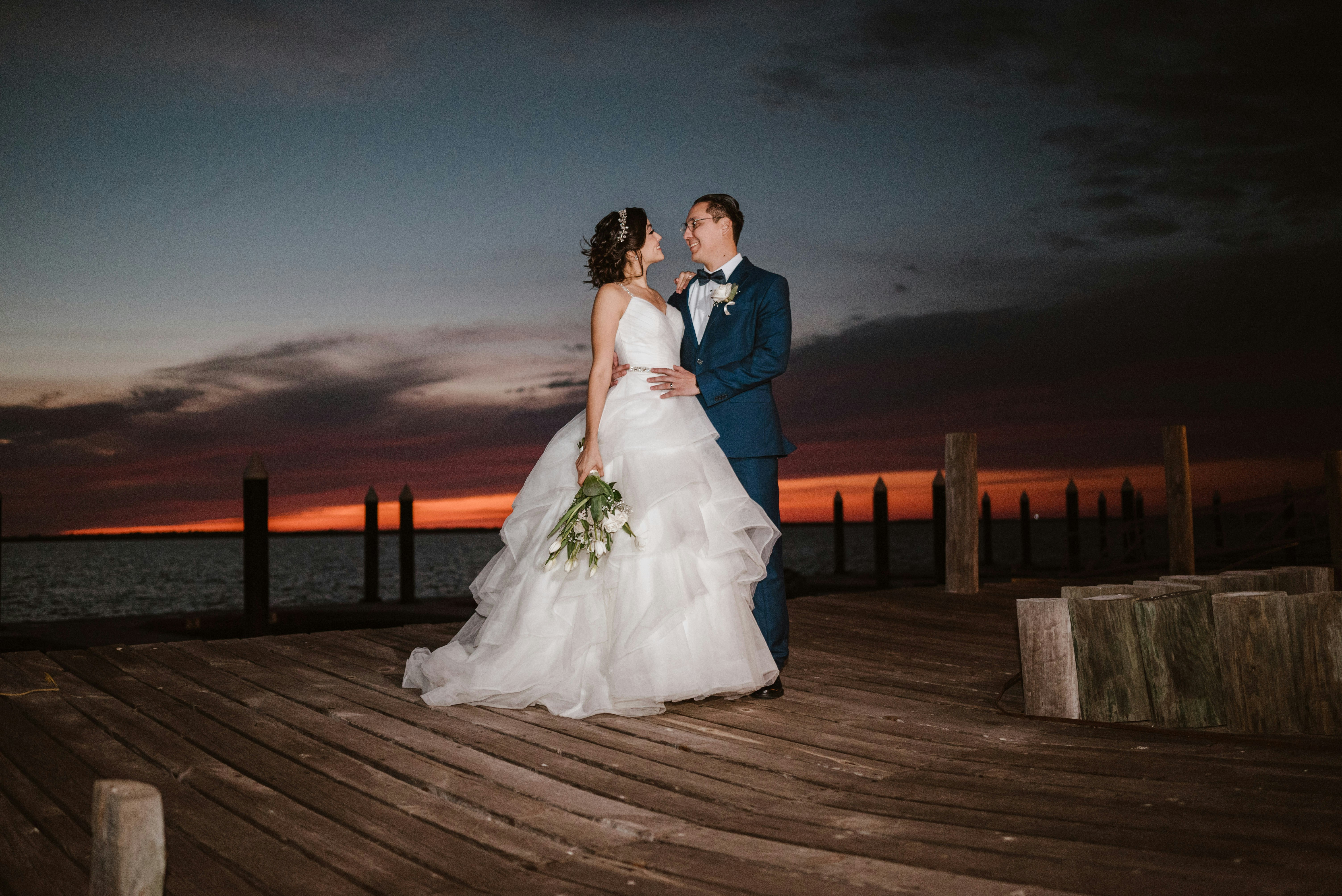 Bride and groom on a dock at sunset