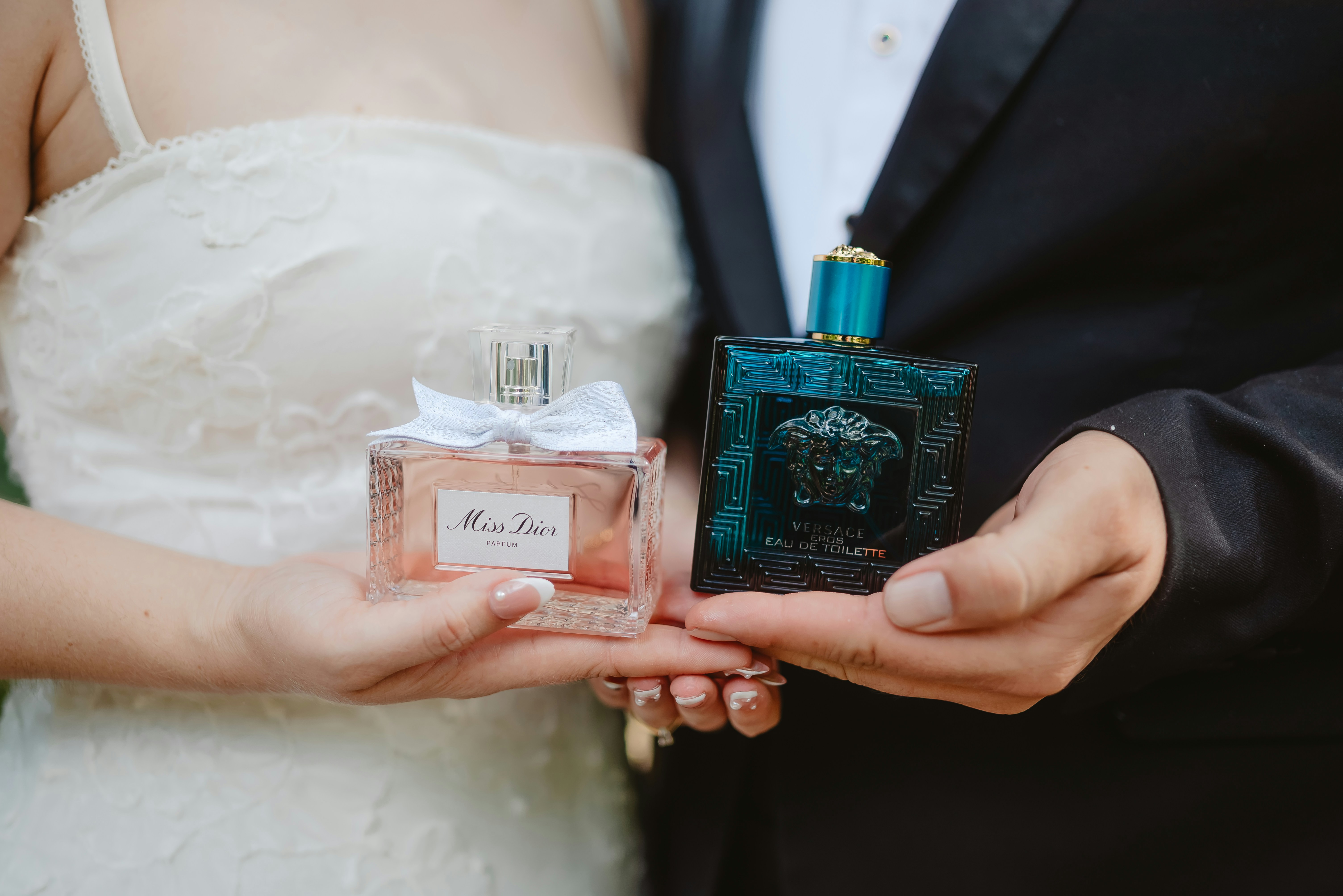 Couple holding perfume bottles