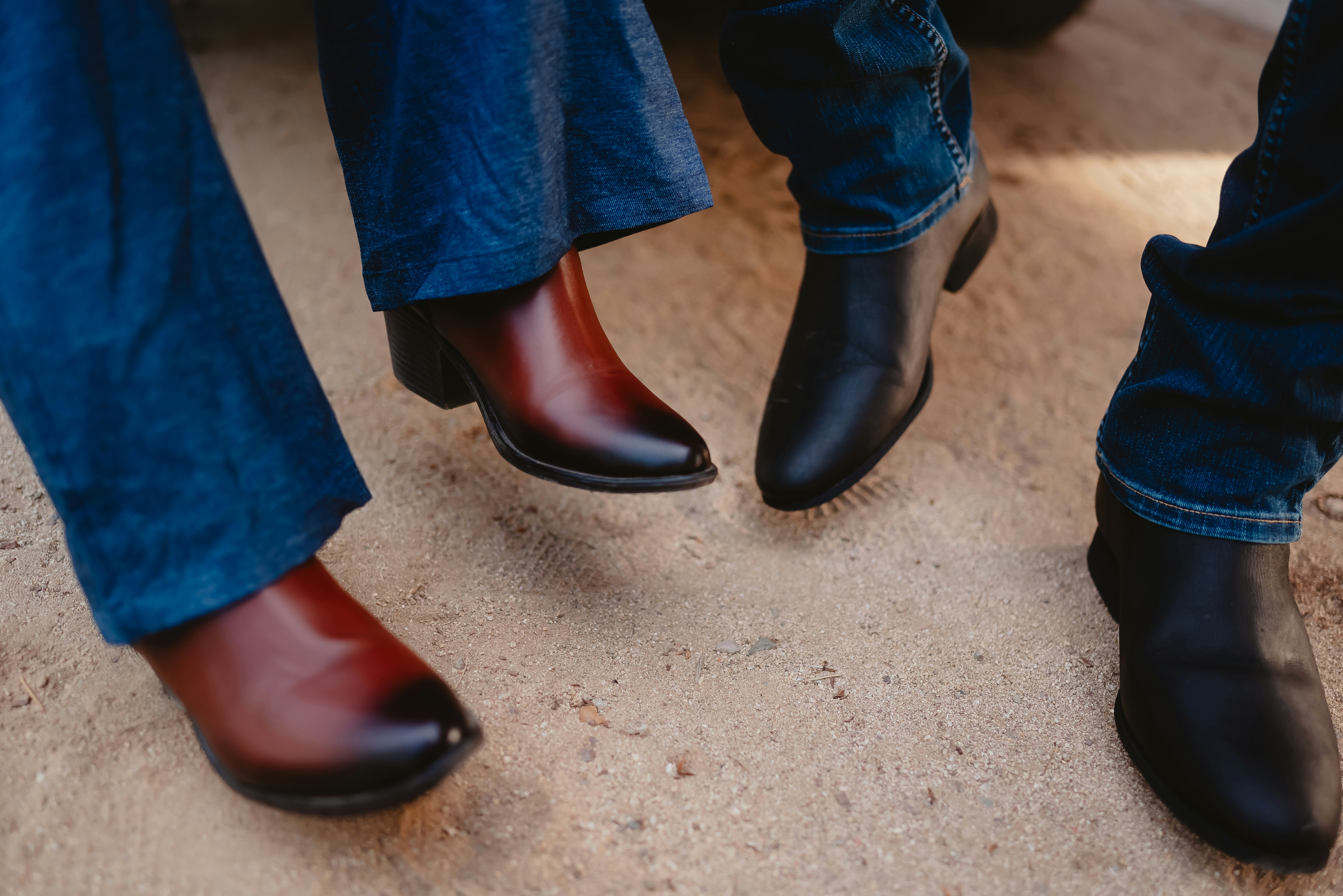 Two pairs of boots on a sandy surface