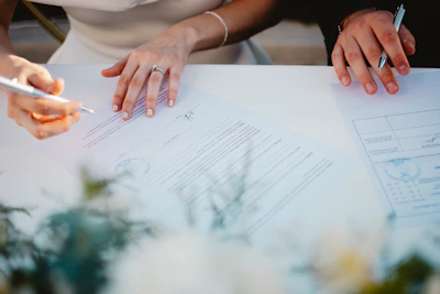 Couple signing marriage documents at a table