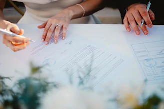 Couple signing marriage documents at a table