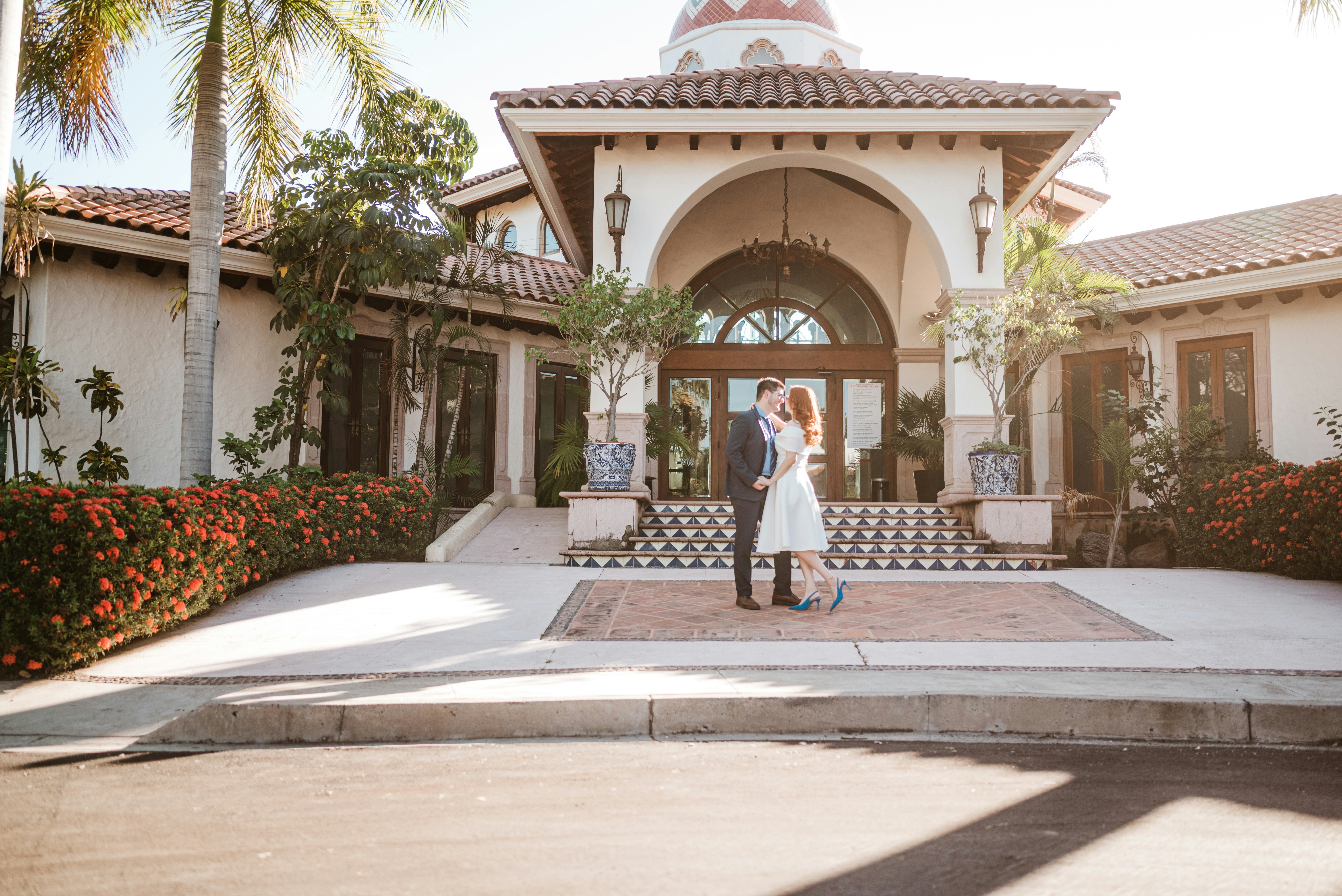 Couple standing in front of a spanish-style building