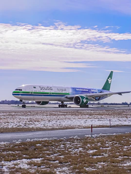 Saudia airplane taxiing on a snowy runway