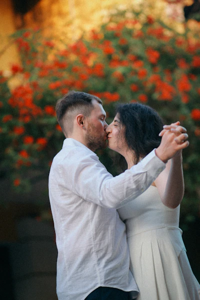 Couple kissing while dancing outdoors with flowers