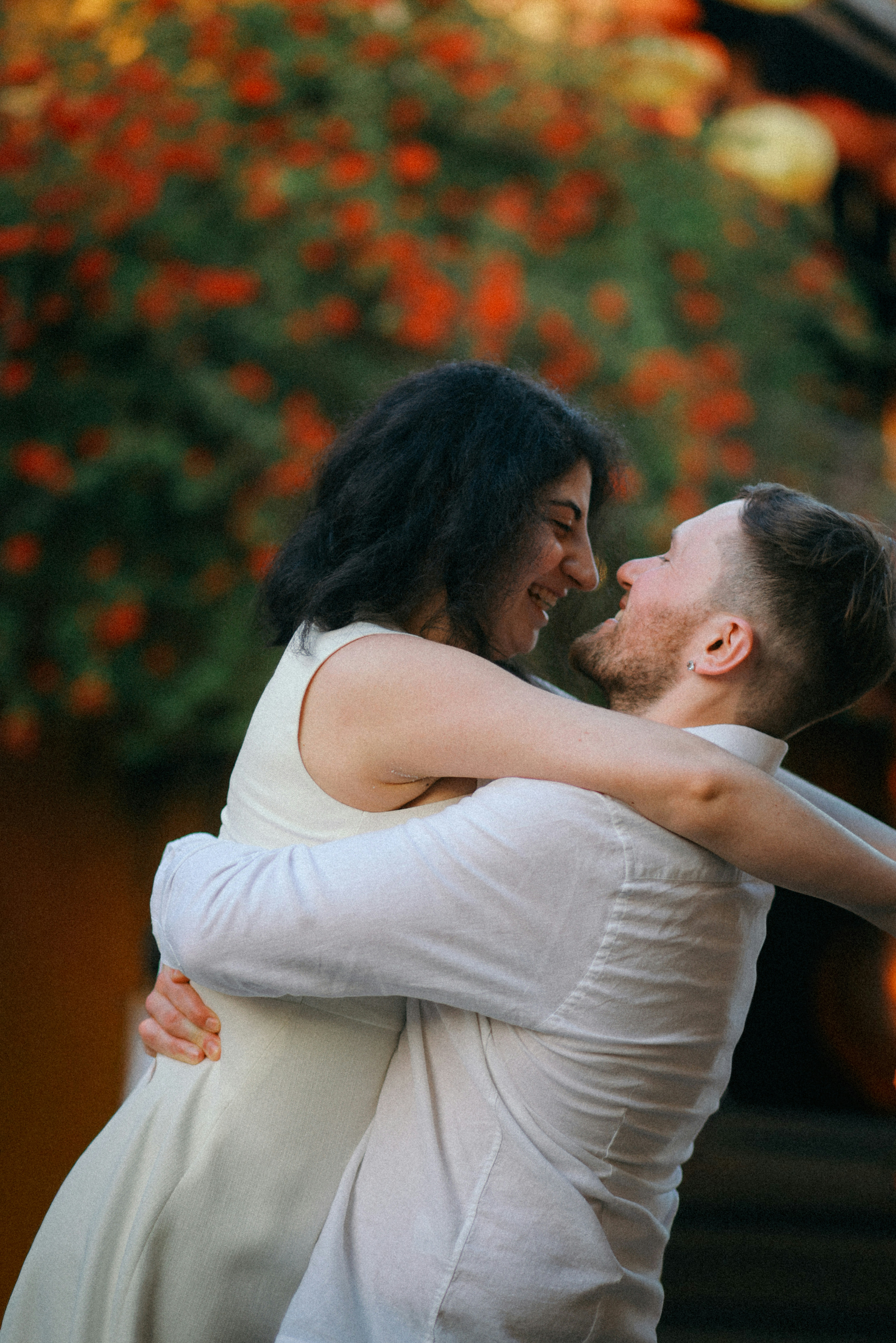 A couple embracing and smiling outdoors