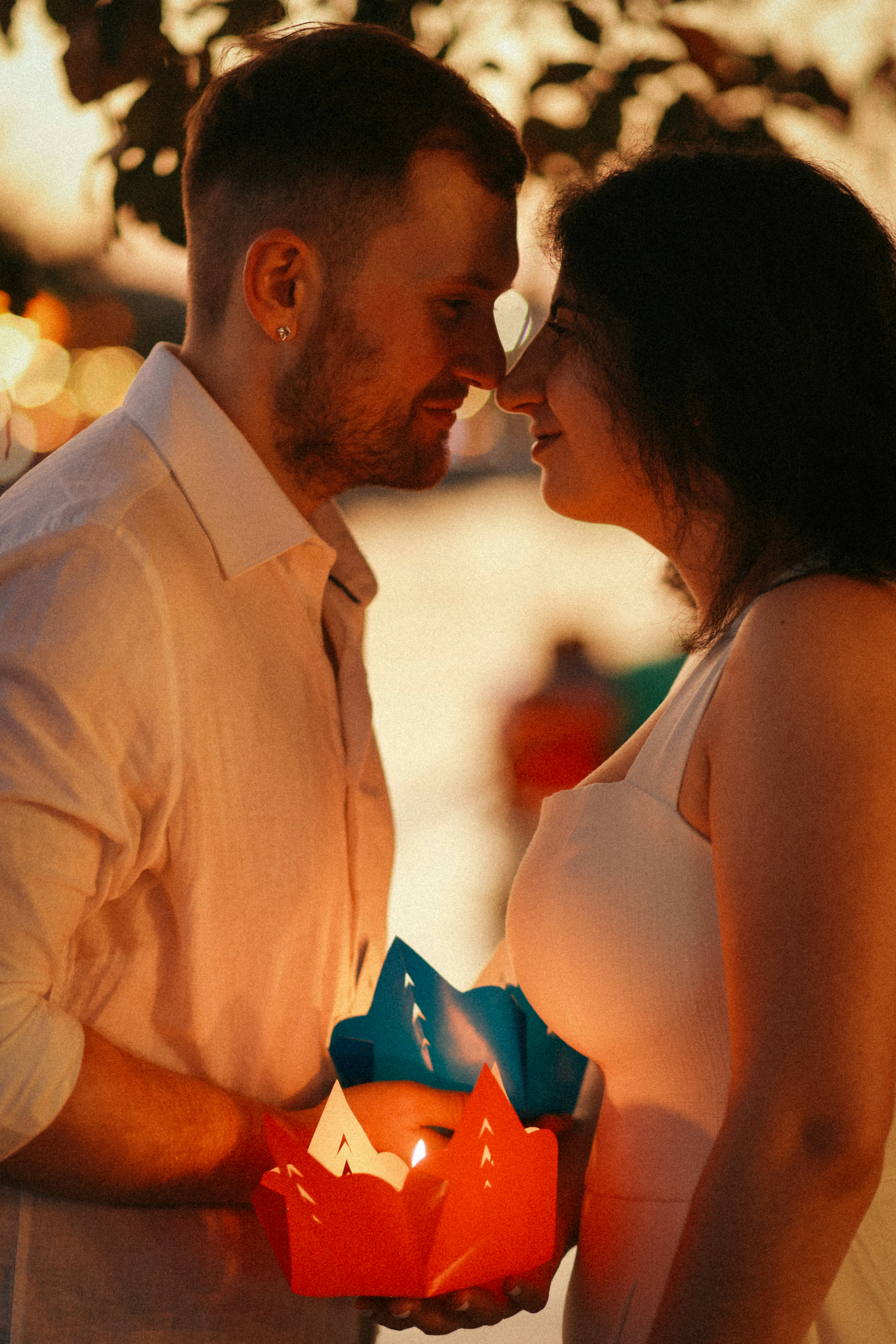 Couple tenant une lanterne allumée au crépuscule