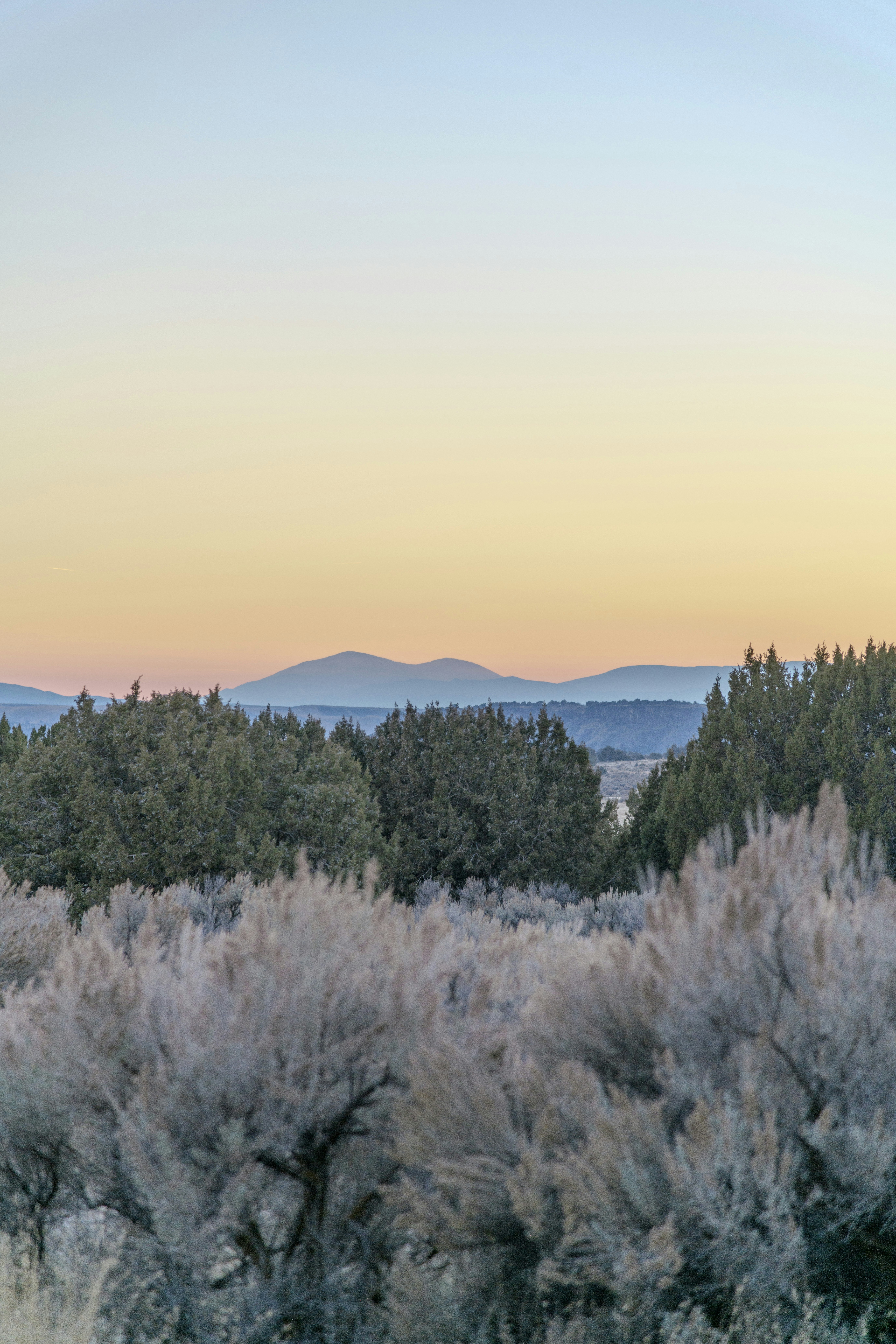 Montañas lejanas visibles sobre un paisaje árido al amanecer