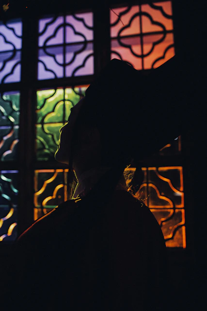 Silhouette of a person against a colorful stained glass window
