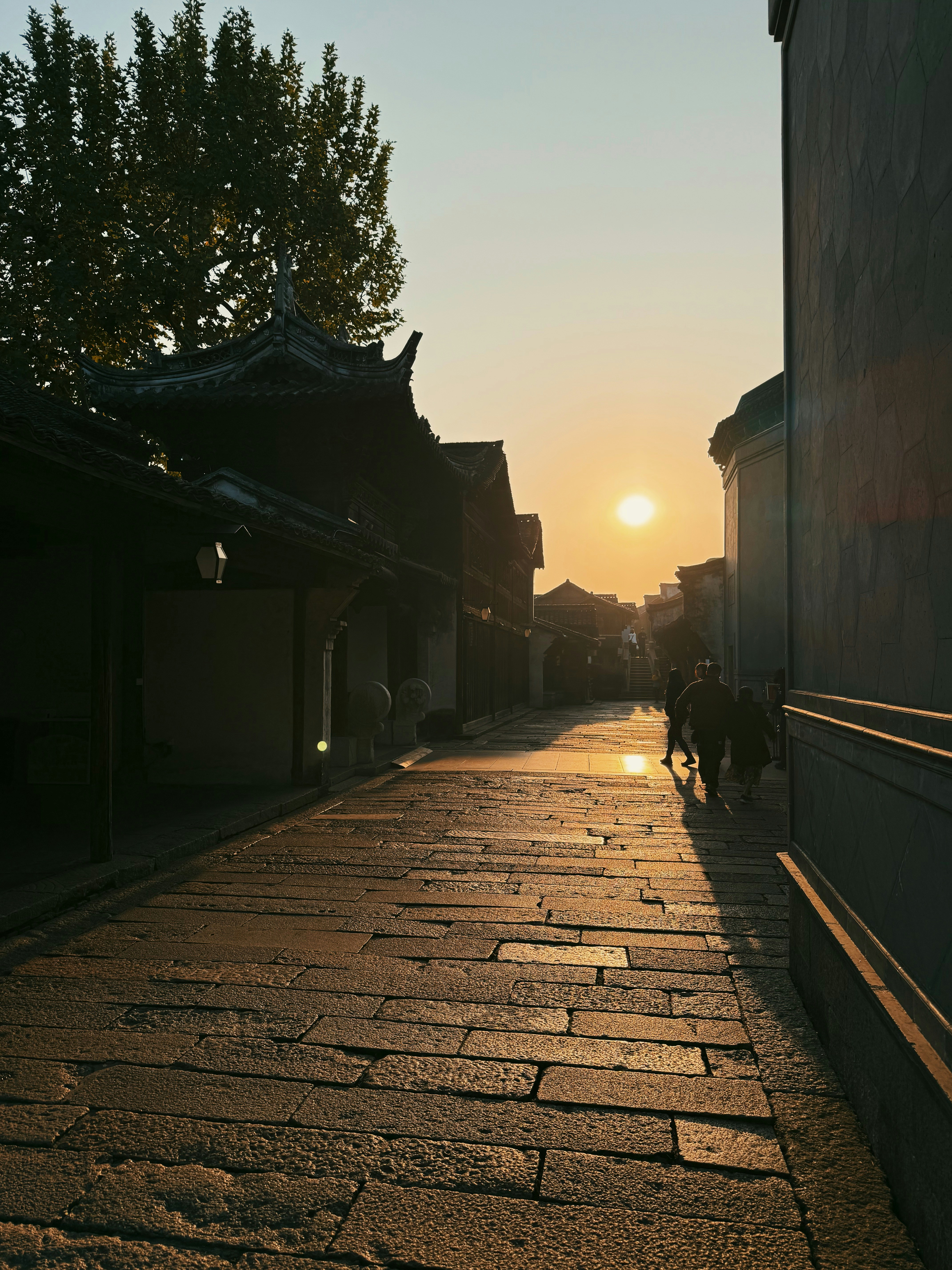 Stone street with traditional buildings at sunset.
