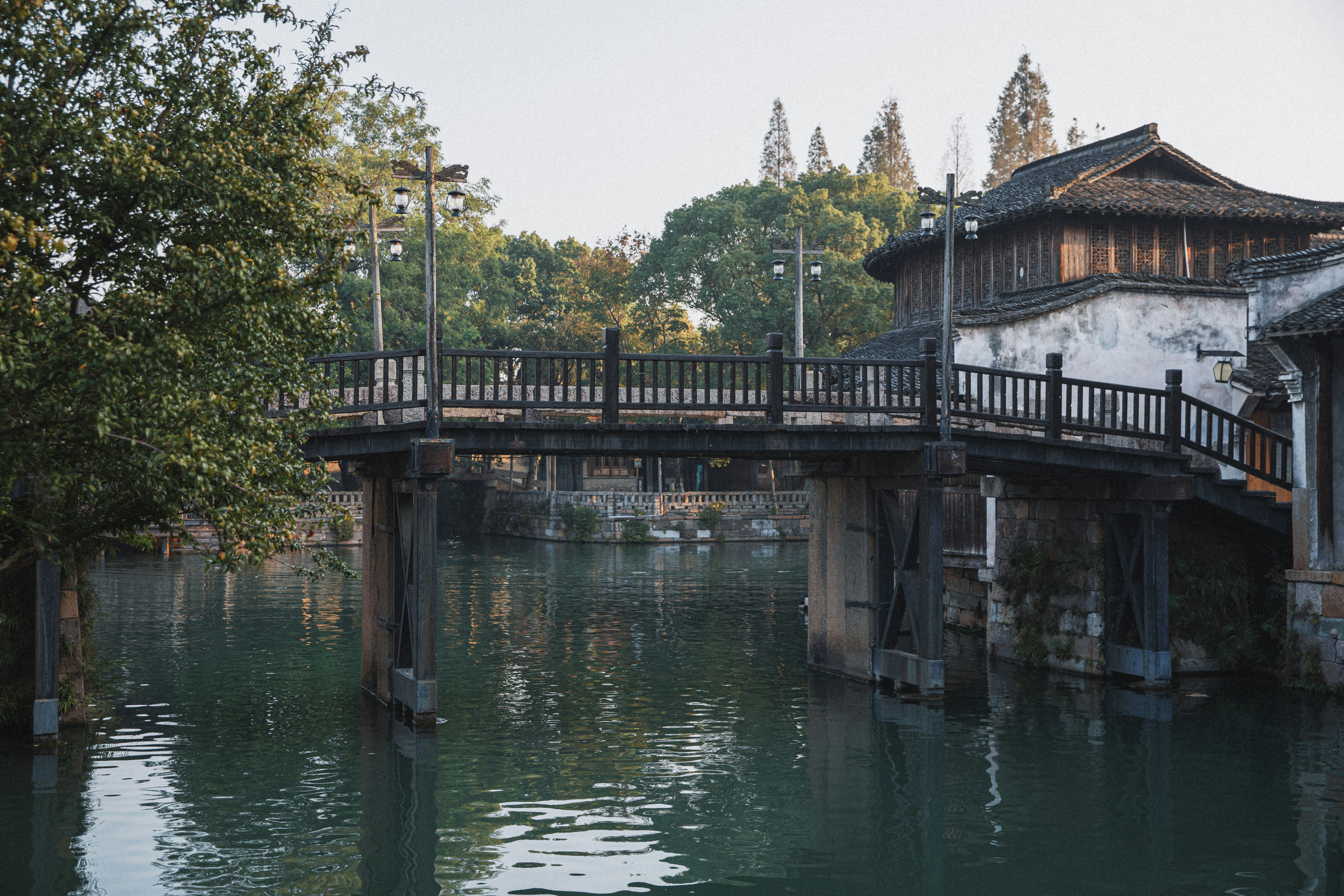 Wooden bridge over a tranquil canal with old buildings.