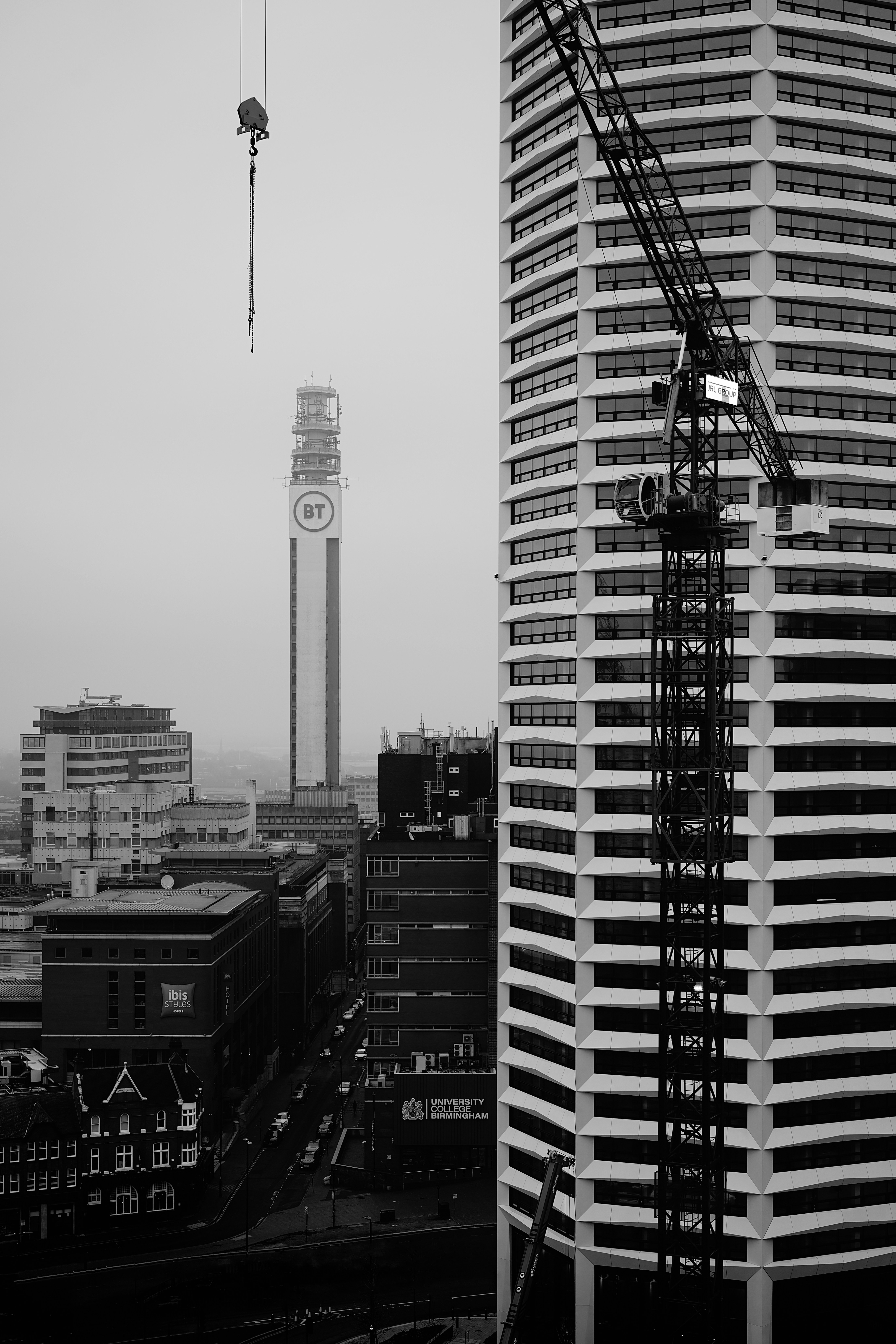 Paesaggio urbano con edifici alti e gru da costruzione.