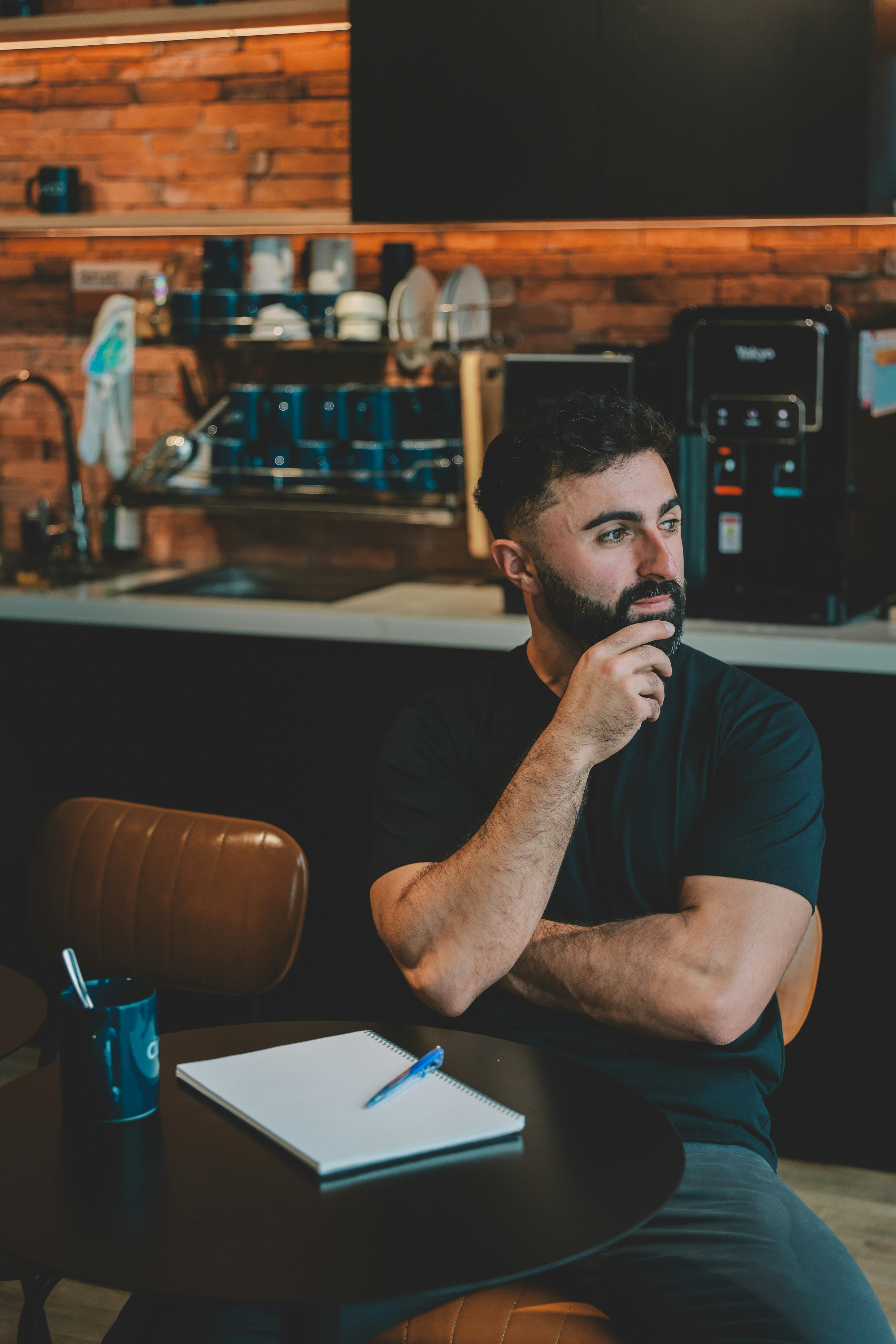 Man sitting at table with notebook and pen