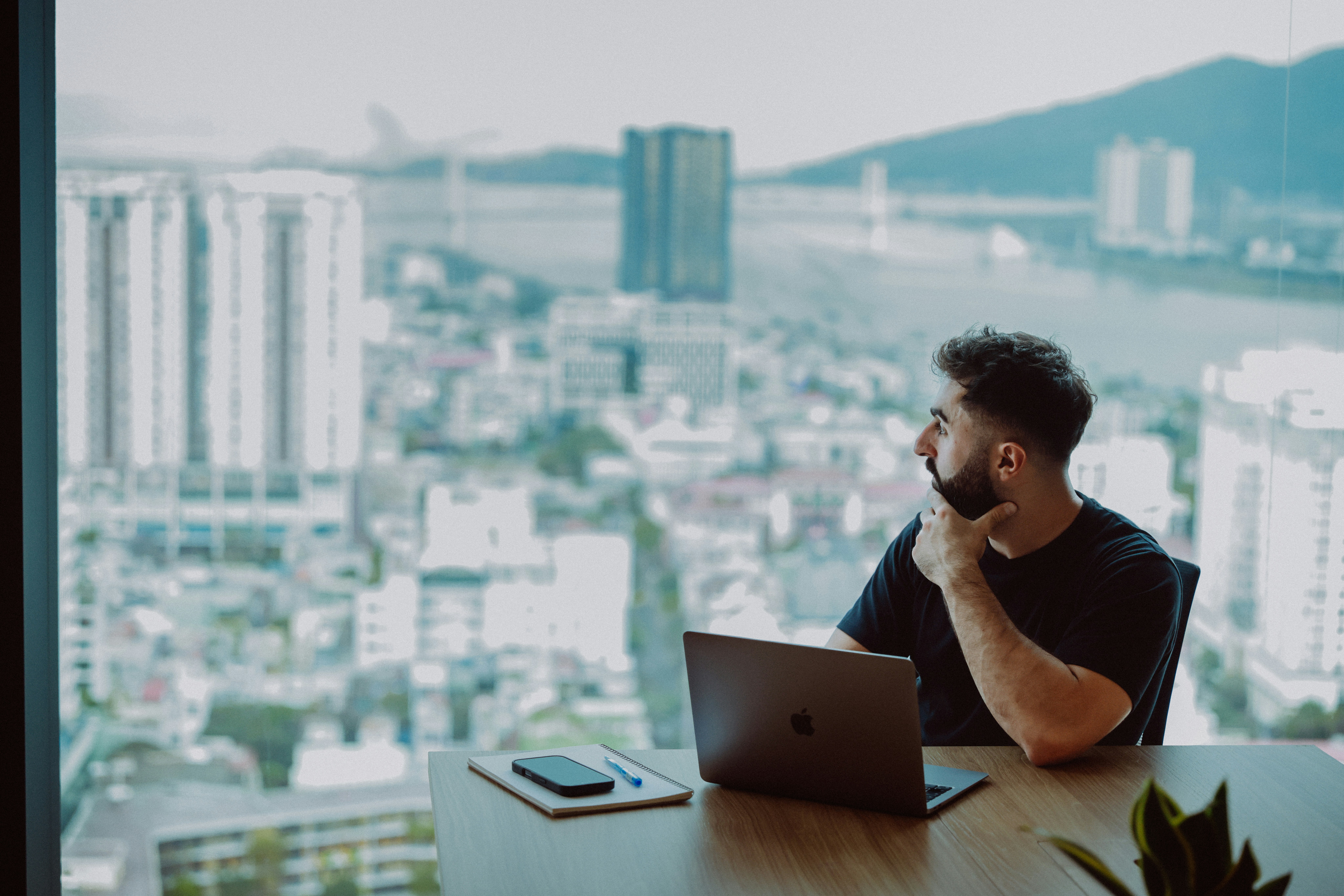 Man looking out window at city skyline