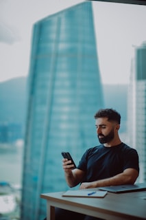 Man looking at phone with city view