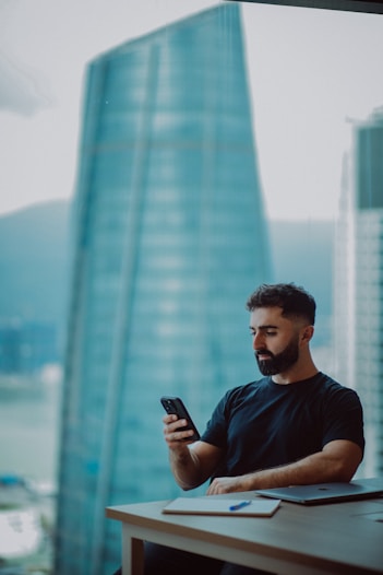Man looking at phone with city view