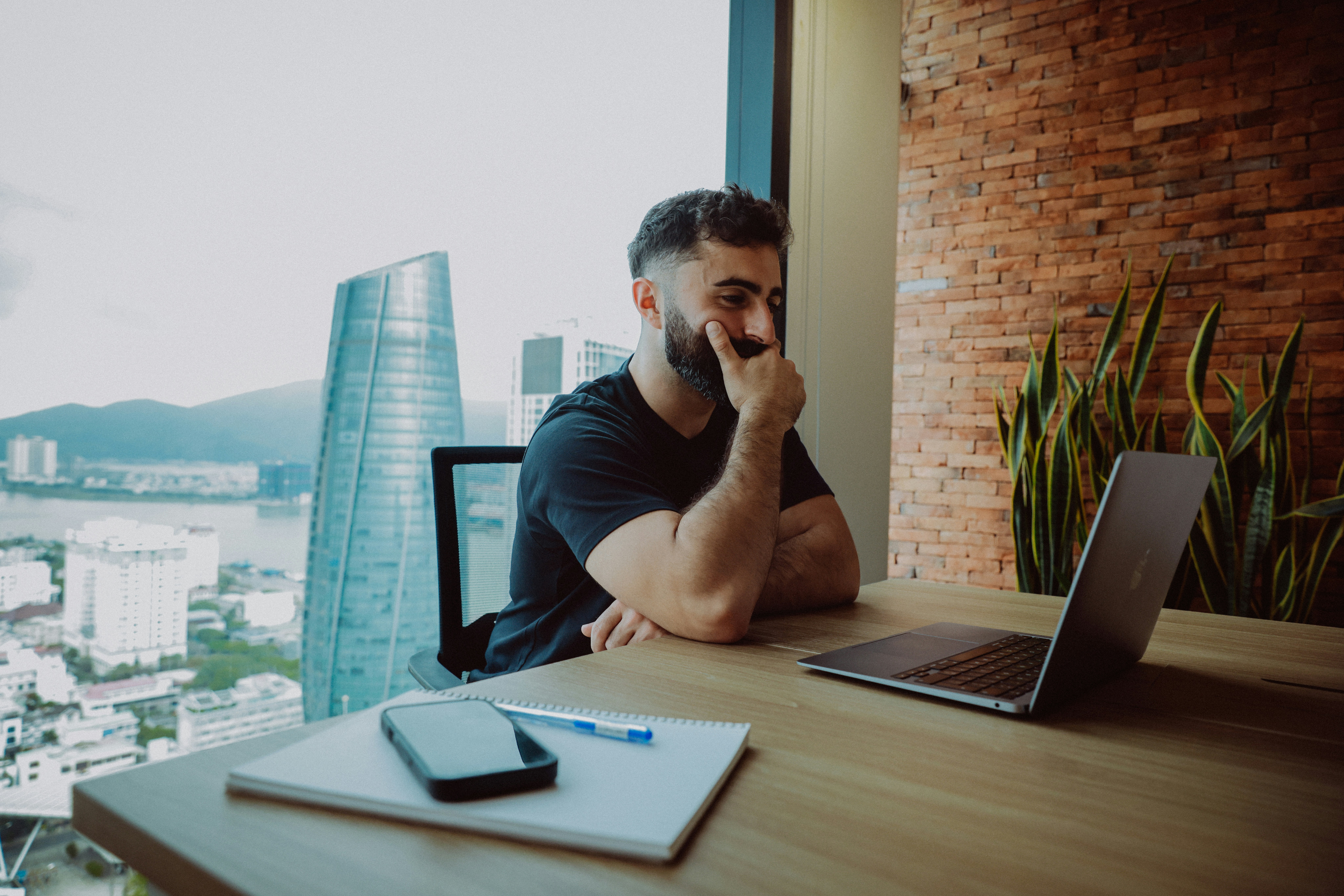 Man working on laptop with city view