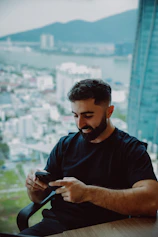 Man with beard using smartphone by the window