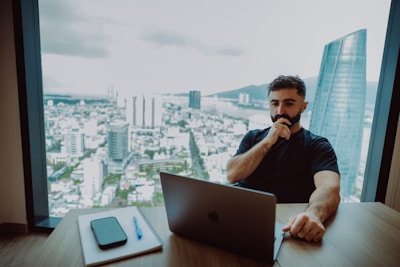 Man working on laptop with city view