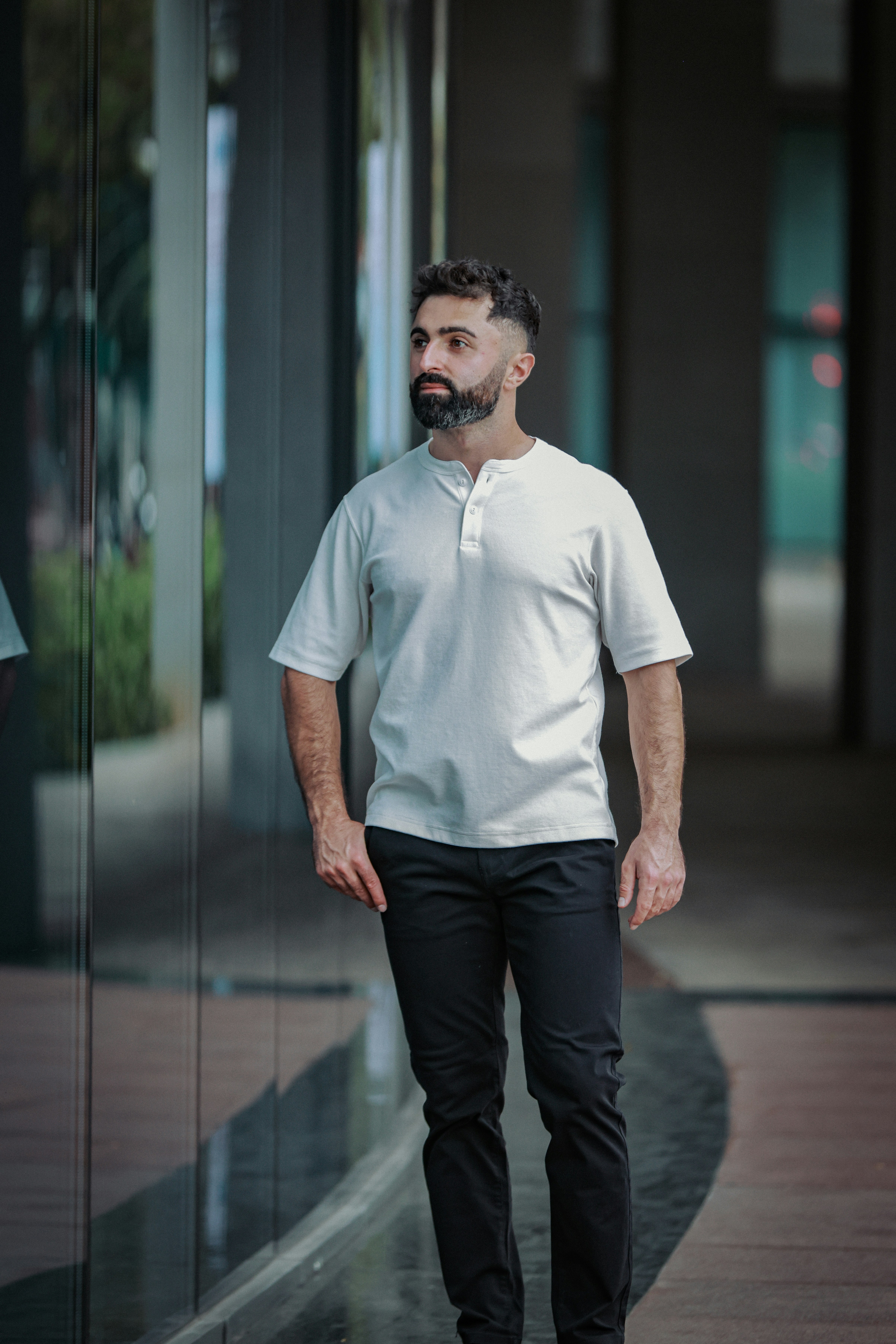 Man in white henley shirt and black pants