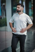 Man with beard wearing white shirt and black pants