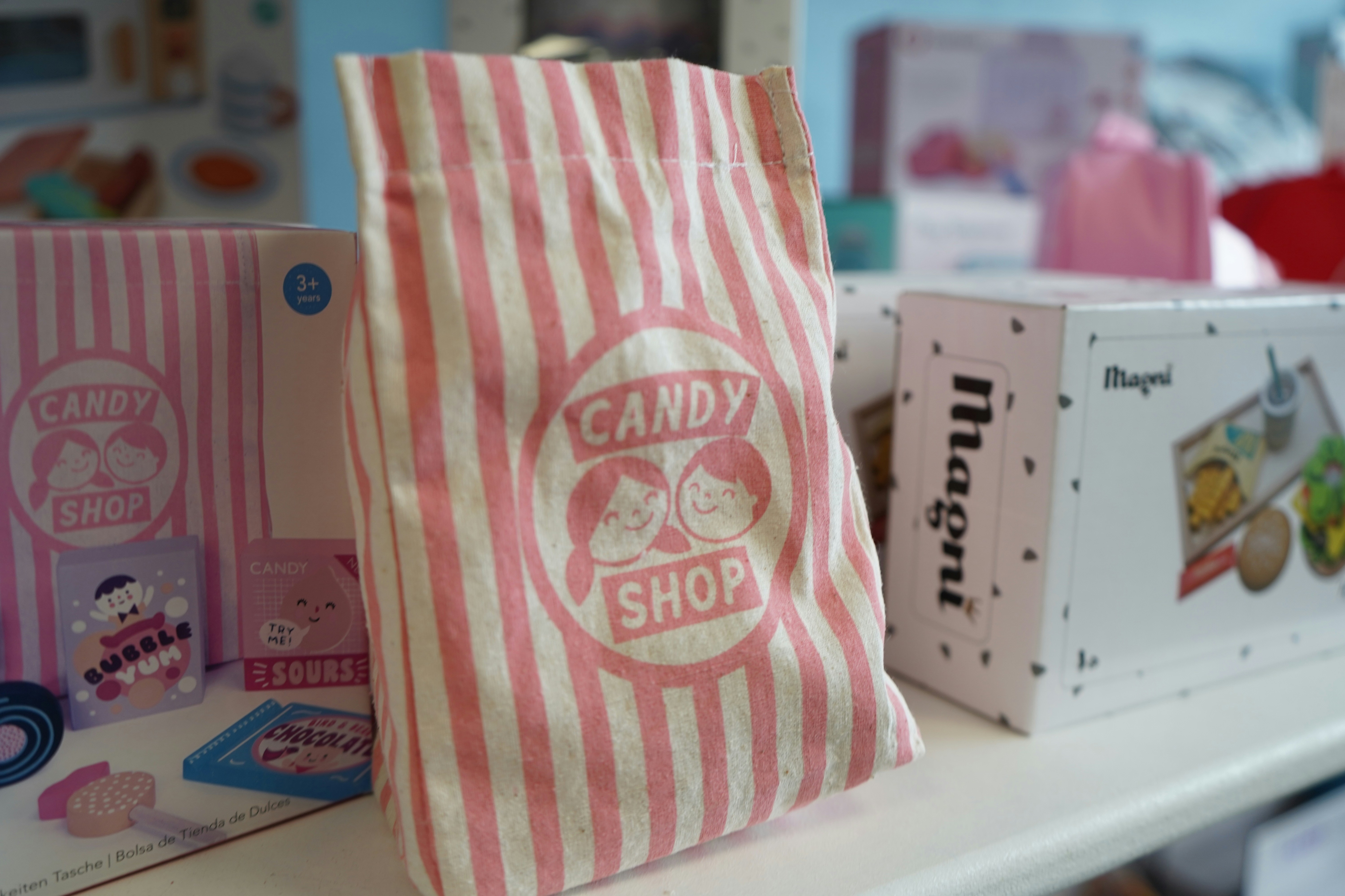 Pink and white striped bag with candy shop logo