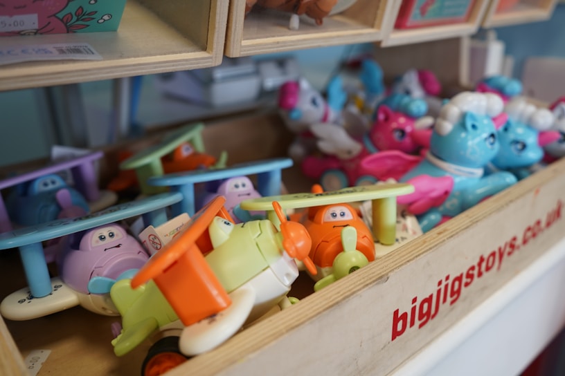 Assorted colorful toys in a wooden bin.
